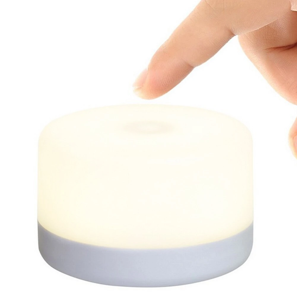 A small, portable USB-rechargeable LED night light lamp with its charging cable.